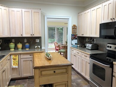 Kitchen with plenty of cabinets and adjoining sunr