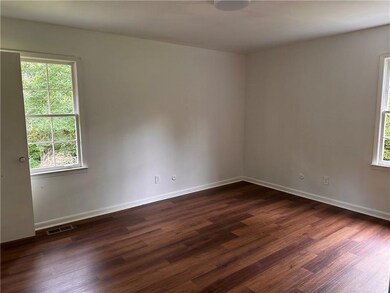 Unfurnished room with healthy amount of natural light and dark wood finished floors