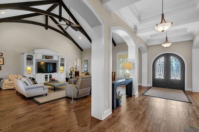 Foyer featuring high vaulted ceiling, dark hardwoo