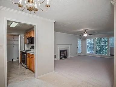 Kitchen with a textured ceiling, gas range, light countertops, brown cabinetry, and crown molding