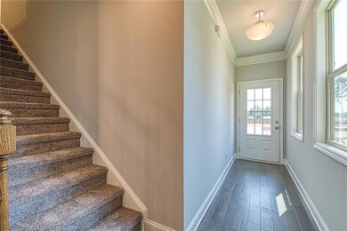 Entryway featuring stairway, baseboards, dark wood