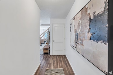 Hallway featuring dark wood-style floors and stairway
