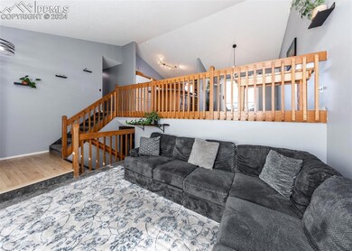 Living room with lofted ceiling and hardwood / woo