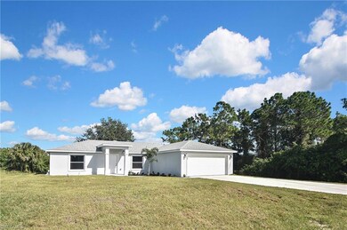 View of front facade featuring a front lawn, driveway, a garage, stucco siding, and a shingled roof