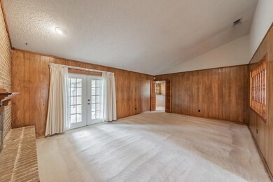 Unfurnished living room with wood walls, french do