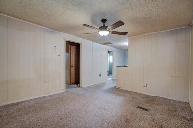 Unfurnished room with ceiling fan, carpet, and a t