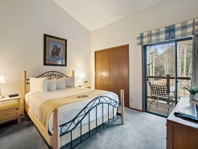 Carpeted bedroom featuring lofted ceiling, a close