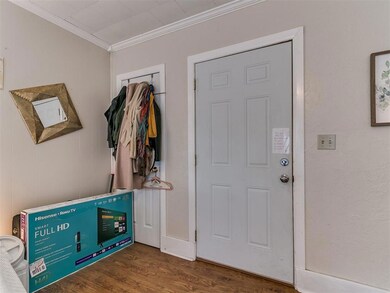 Foyer entrance with crown molding and dark wood-ty