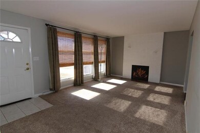 Living Room with new carpet and brick fireplace.