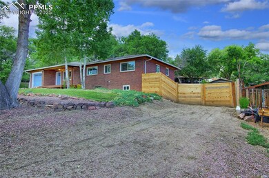Ranch-style home featuring brick siding, an attached garage, and dirt driveway
