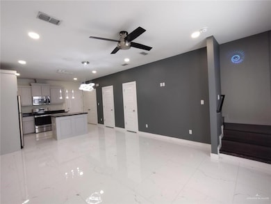 Unfurnished living room with ceiling fan, recessed lighting, light marble finish floors, and stairway