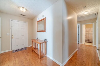 Entryway with light wood-type flooring, a textured ceiling, and baseboards