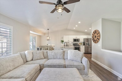 Living room with vaulted ceiling, dark wood-style flooring, a ceiling fan, and recessed lighting