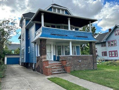 View of front of house featuring a balcony, a garage, a front lawn, and covered porch