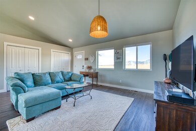 Living room featuring vaulted ceiling, recessed lighting, and dark wood-type flooring