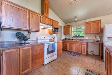 Large, lovely kitchen has custom built cabinets an