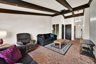 Living room with carpet flooring and a chandelier