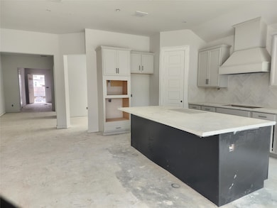 Beautifull kitchen with large island covered with quartz countertops! Beautiful y designed vent hood.