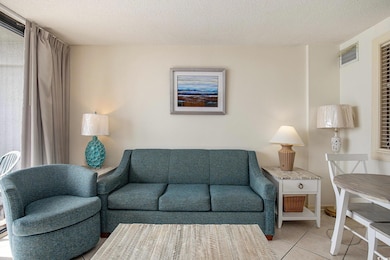 Tiled living area featuring a textured ceiling
