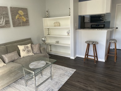 Light and bright living room overlooking the kitchen with Granite countertops and stainless steel appliances