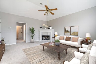 Carpeted living room featuring a tiled fireplace, 