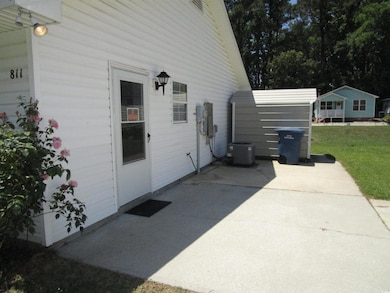 View of side of home featuring a patio, cooling unit, and a yard