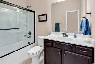 Full bathroom featuring tile patterned flooring, toilet, vanity, and shower / bath combination with glass door