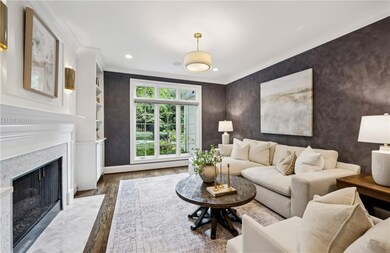 Living area featuring wood finished floors, ornamental molding, a fireplace, and recessed lighting