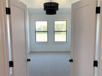 Spare room featuring carpet and a notable chandeli