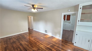 Empty room with wood finished floors, ceiling fan,