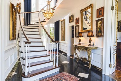 Tiled foyer entrance featuring crown molding and a