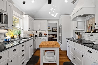 Kitchen featuring custom exhaust hood, lofted ceil