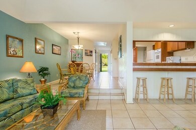 The unit has cool tropical hues and there is additional dining space at the kitchen bar.