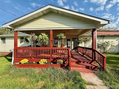 View of front of home with covered porch and a front lawn