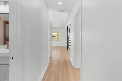 Hall with light wood-style floors, recessed lighting, and stairway