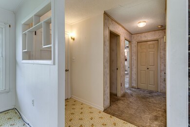 The front door leads to a foyer that opens to the living room, dining room, kitchen & hallway to the bedrooms.