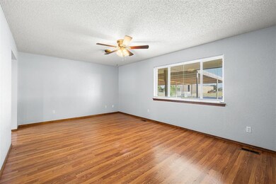 Unfurnished room with ceiling fan, a textured ceil