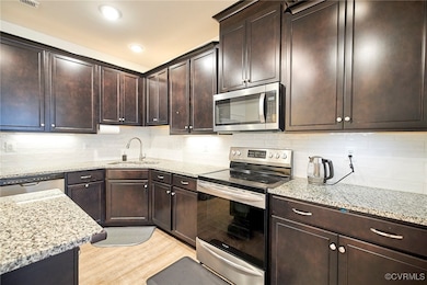 Kitchen featuring backsplash, appliances with stai