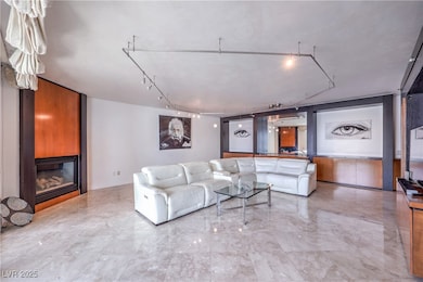 Living area with a large fireplace, rail lighting,