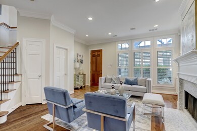 Wall of windows with transoms and wood shutters allows for natural lighting to flow throughout the room.
