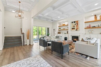 Living room with a high end fireplace, light hardw