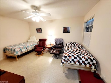Bedroom with a textured ceiling and ceiling fan