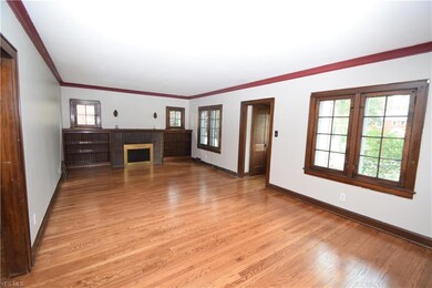 Large great room with fireplace and bookshelves.  Beautiful windows with new storm windows.  Astounding refinished original hardwood floors