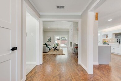Hallway featuring baseboards, visible vents, crown