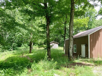 Side view of barn house and back yard with wood barn