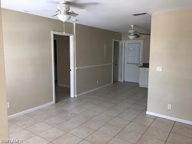 Spare room with a ceiling fan, light tile patterned floors, and baseboards
