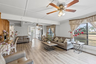 Living room featuring a ceiling fan, wood finishe