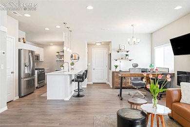 Living area with a dining area (currently used as office), light wood-style flooring, a chandelier, recessed lighting, and baseboards