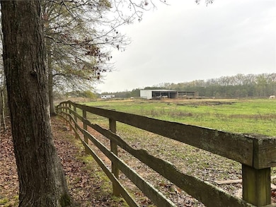 Gate with an outbuilding, a view of rural / pastoral area, and a pole building