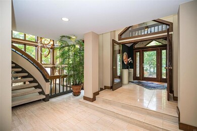 View of curved staircase to upstairs with open atrium to lower level.